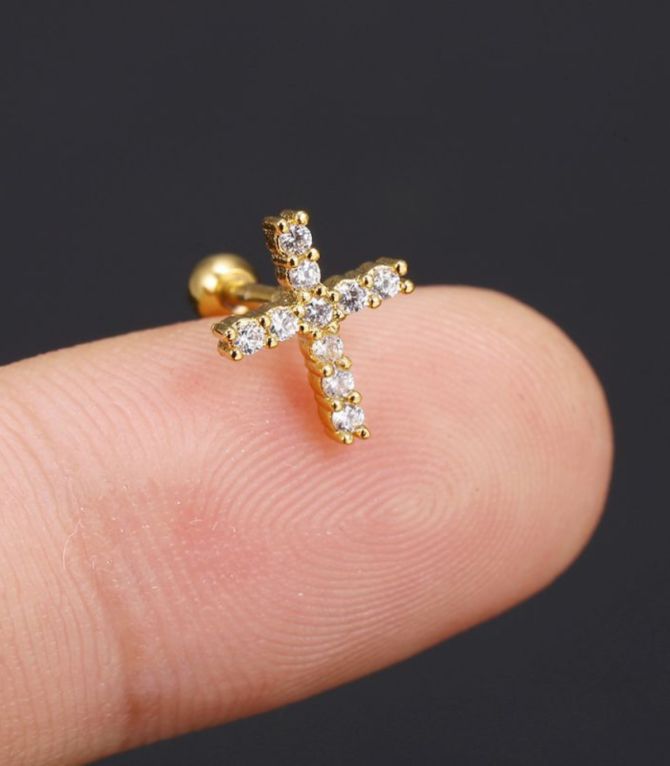 Piercing dorado cruz